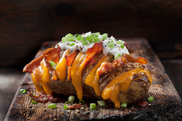 Cheesy, Hasselback Potatoes Stuffed with Cheddar and Bacon with Sour Cream and Green Onions Cheesy, Hasselback Potatoes Stuffed with Cheddar and Bacon with Sour Cream and Green Onions baked potato sour cream stock pictures, royalty-free photos & images