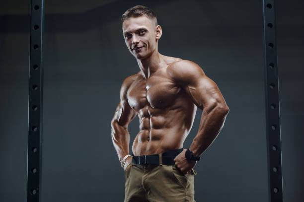 istock Fitness man pumping up abs muscles in gym 1289781423