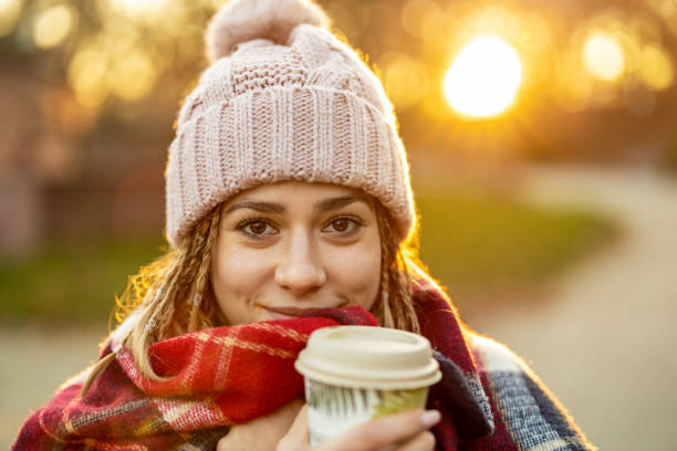 istock Young woman with coffee cup smiling outdoors during winter 1289782207