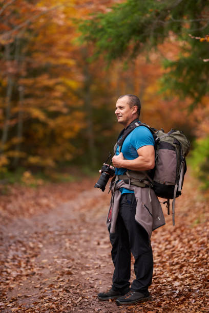 istock Nature photographer shooting fall scene in the forest 1289783381