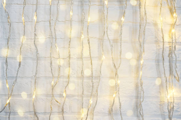 istock Christmas background with shining lights. White brick wall. 1289785345