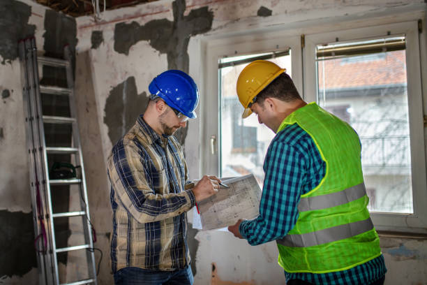 istock Engineer and architect looking at building blueprint at the construction site 1289788835