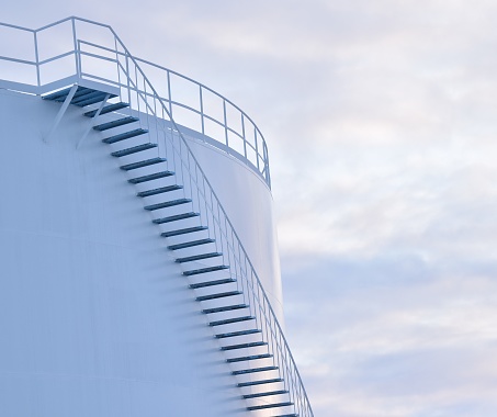 Closeup of large oil tank, detail of stairs and railing. Soft, blue and gray lighting.