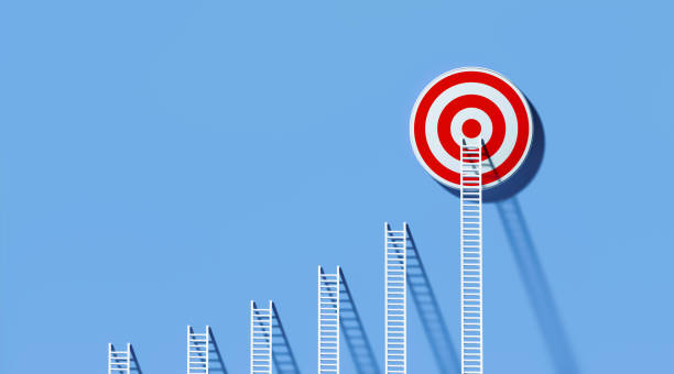 istock White Ladders Leaning on A Red Bull's Eye Target on Blue Wall 1289803147