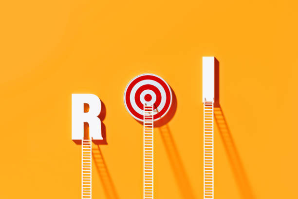 istock White Ladders Leaning on ROI Written Bull's Eye Target on Yellow Wall 1289804984