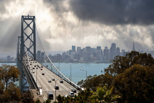 View of traffic on the Bay Bridge with downtown San Francisco and stormy sky in background
