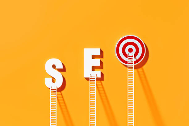 White ladders leaning on SEO written bull's eye target on yellow wall. Horizontal composition with copy space. SEO concept.