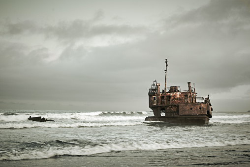 Stranded car wreckage on sandy beach in Cape York peninsula Queensland, Australia.