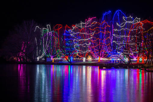 Long exposure landscape texture view of colorful Christmas holiday lights reflecting across a frozen lake in Sleepy Eye, Minnesota.
