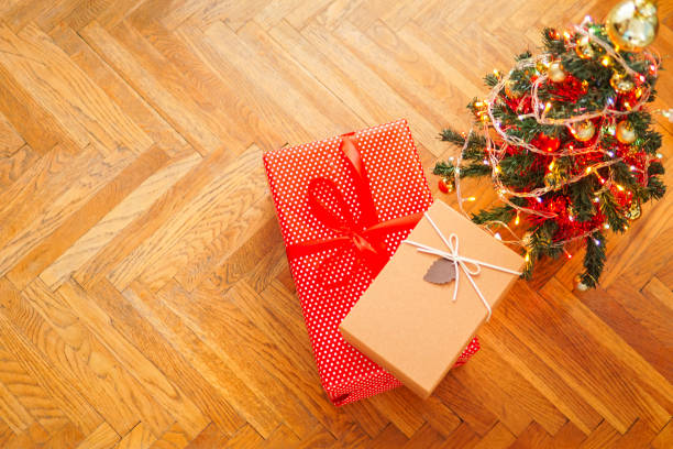 istock Christmas presents and decorated tree, gift boxes and christmas tree with lights on the floor with copy space for text 1289813447
