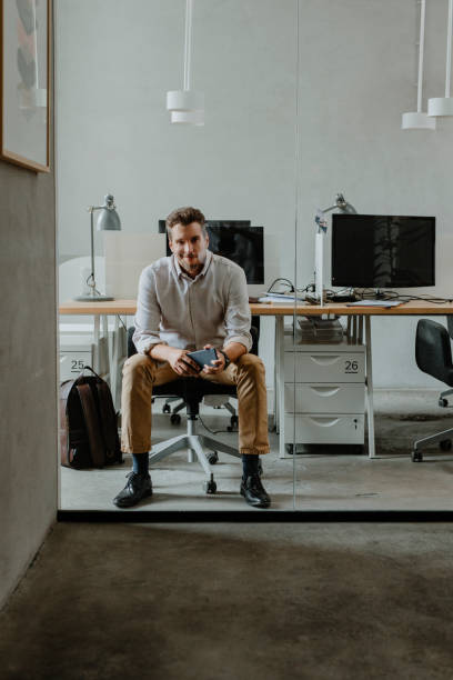 istock Elegant Handsome Businessman Using his Smartphone in the Office, Staying Connected at Work 1289815590