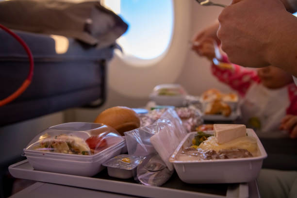 istock close-up passenger plane eats tasty hot meal  on board  on a folding table. in the background is a window in the porthole. 1289817946