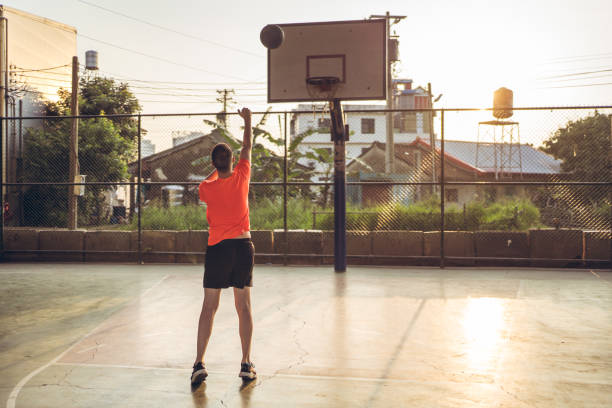 istock Caucasian young man playing basketball alone 1289819614