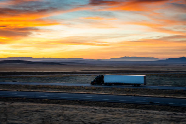 istock Semi-Trailer truck speeding down I-70 Interstate under a rural Utah Sunset 1289819720