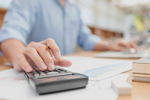 istock businessman hold pen and using calculator for calculate budget accountancy, business data. finance and accounting concept 1289820611