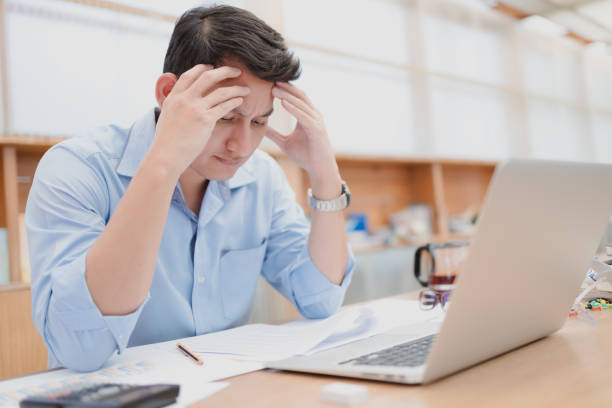 istock Tired businessman at workplace in office holding his headache or angry. Overworking, making mistake, stress, termination, fail, bad, sad tired or depression concept 1289821522