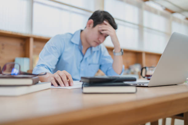 istock Tired businessman hold pencil at workplace in office and headache or angry. Overworking, making mistake, stress, termination, fail, bad, sad tired or depression concept 1289821972