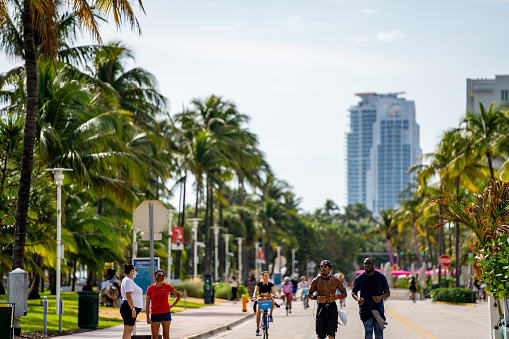 Miami Beach, FL, USA - December 6, 2020: Street photography Miami Beach men running and palm trees