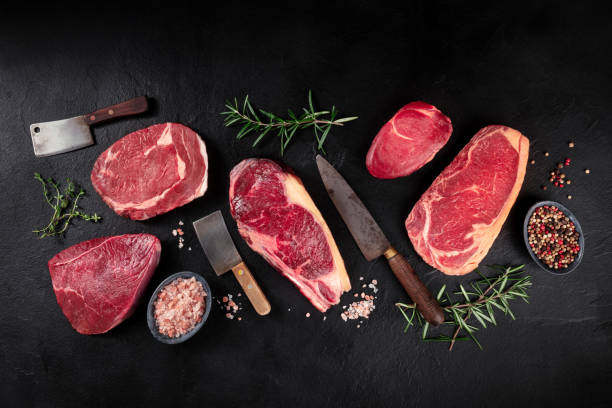 carne piatta laici. vari tagli di carne, colpo di laici piatto in testa con coltelli, sale, pepe ed erbe aromatiche - strip steak steak sirloin steak rib eye steak foto e immagini stock