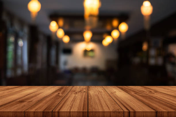istock Empty wooden table top with blurred coffee shop or restaurant interior background. 1289832234