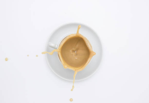 White Cup and saucer with cappuccino and splash. Top view, white background. Free space for text.