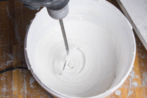 istock mixing wall putty with a whisk in a bucket, for finishing application 1289832784