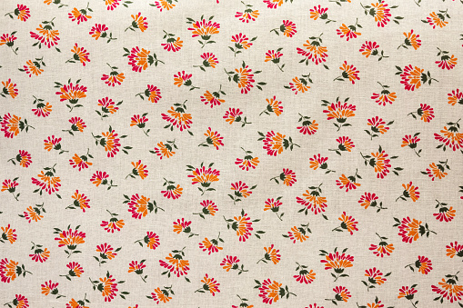 Cotton fabric with an abstract flower pattern on a beige background. As a natural background.