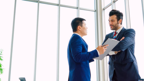 istock Two business people talk project strategy at office 1289835452