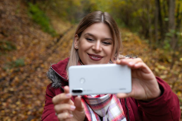 istock Woman making online content outdoor-autumn 1289835629
