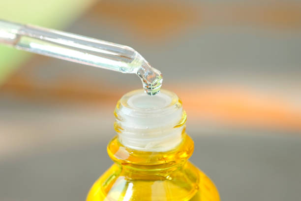 istock Dropping serum collagen moisturizer of face into clear yellow bottle soft light background. Protector skin Treatment facial essence oil, Vitamin C. Beauty and spa Concept 1289835786