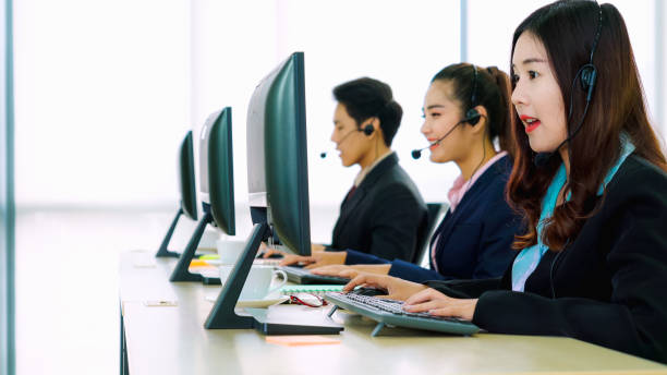 istock Business people wearing headset working in office 1289836600
