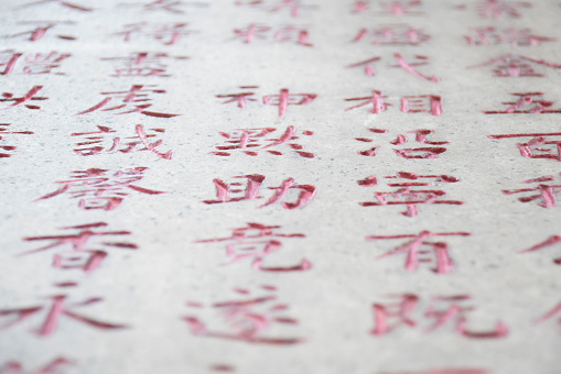 Carving of chinese writing on stone in red ink