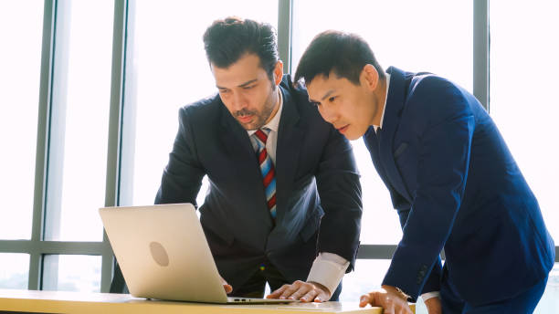 istock Two business people talk project strategy at office 1289841464