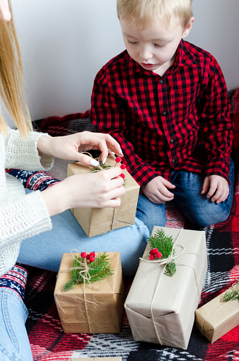 Mother giving a Christmas gift to child. Merry Christmas concept. Seasonal greetings card. Happy holidays. Top view.
