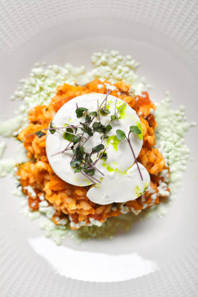 Tomato Risotto with Burrata and Pesto. Gray vintage table. Textile, kitchenware