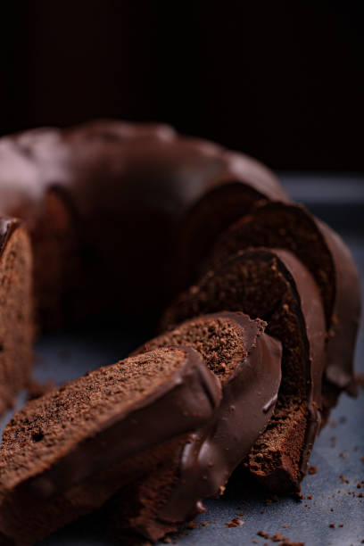 istock Dark chocolate cake covered with icing covered on a dark background. Selective focus. 1289843550