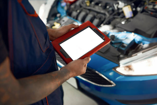 istock Tablet screen in mechanic hands on open hood background 1289850269
