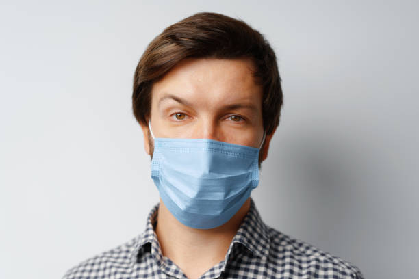 istock Man wearing hygienic mask against grey background 1289854200