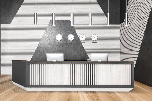 istock Reception desk in open space lobby with clocks, black and white wall, wooden floor 1289855253