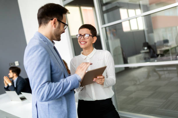 istock Business people having fun and chatting at workplace office 1289859076