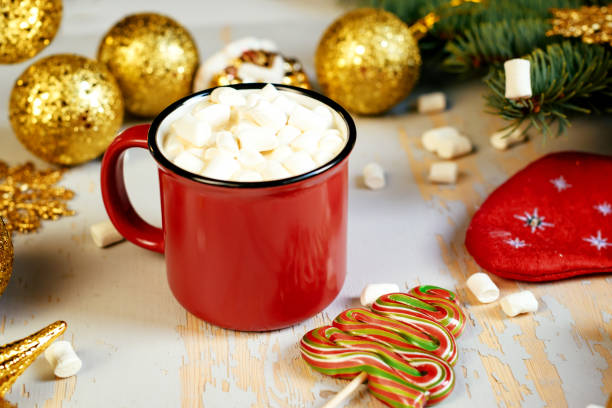 istock Christmas background. Happy new year. Red mug with hot chocolate, white marshmallows and candy in the shape of a Christmas tree on a black background. Selective focus. 1289860512