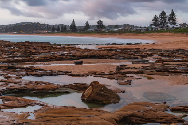 istock Cloudy sunrise from rock platform at the seaside 1289860807