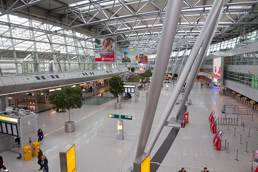 High angle view into departure hall of airport Duesseldorf. A few people are walking in hall