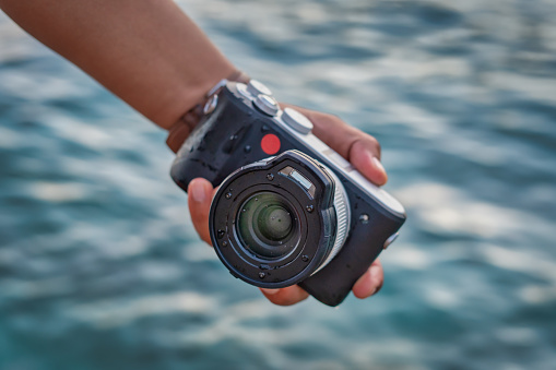Hand holding camera on the water
