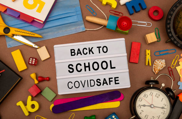 istock Back to school sign after covid-19 pandemic on table top view 1289863463