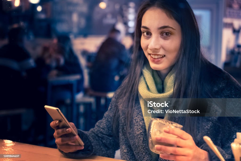I love the atmosphere of the Christmas holidays A young girl talk on the phone in the evening and enjoys the atmosphere of the Christmas holidays Adult Stock Photo