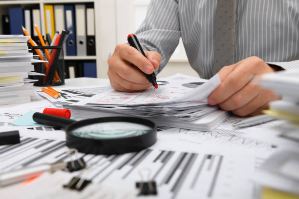 istock business concept - businessman working with reports in office, table and workspace close view, analyzing financial data, writes and counts 1289866933