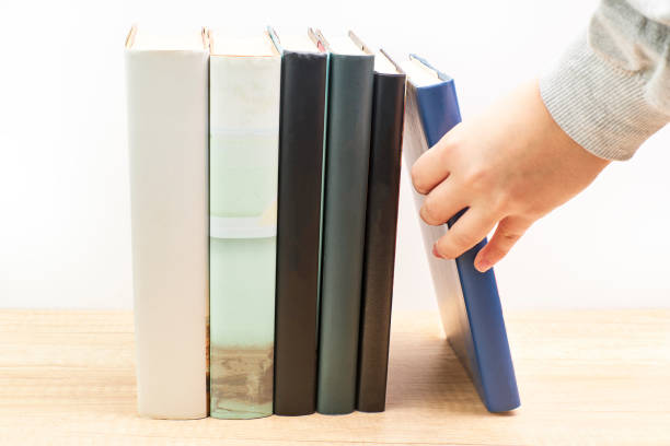 istock Woman taking a reading book that is on a table 1289868333