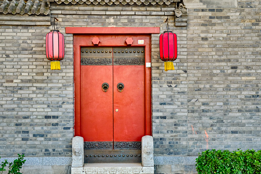Traditional Hutong alley in Beijing, China, Vintage door with red lanterns