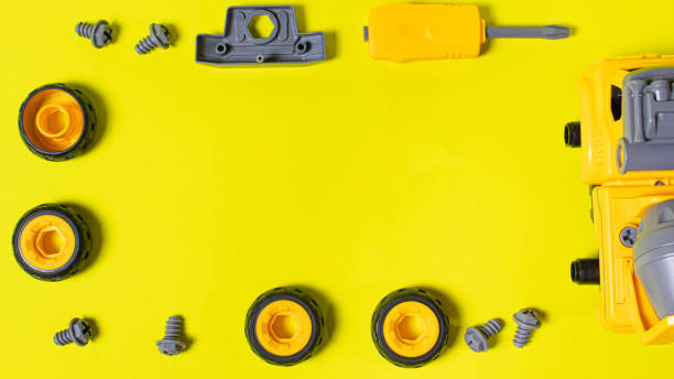istock Construction machine concrete mixer made of plastic on a yellow background with a place for text copy space. Toy with cogs and screwdriver, which can be disassembled into details. Toy-designer. Banner for toy store 1289868770